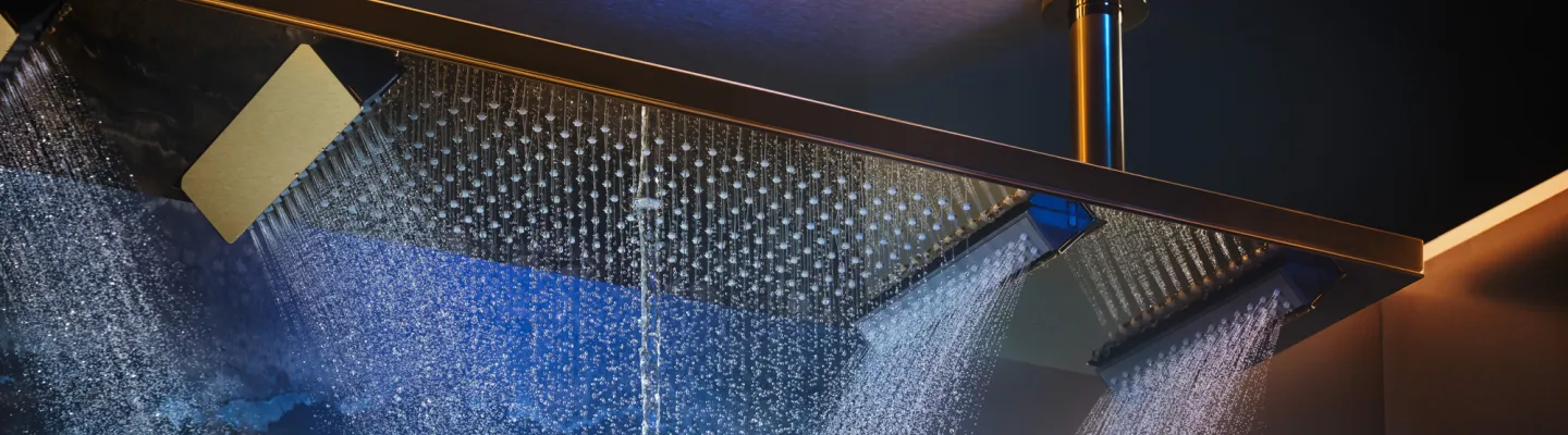 Overhead rainfall shower with three square panels; water streams cascade in a modern shower, bathed in blue and amber lighting.
