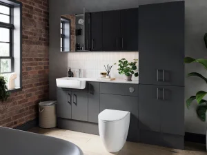 Modern bathroom with dark grey cabinetry, white sink and toilet, white tiled splashback, brick wall and a large window, plus a potted plant on the counter.