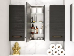 Row of white freestanding cabinets with open doors displaying bottles, jars, towels and toiletries on shelves against a pale wall and wooden floor.