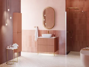 Pink-toned bathroom featuring a marble vanity, an oval backlit gold mirror, pendant lights, gold fittings, tiled walls, a shower and a freestanding tub.