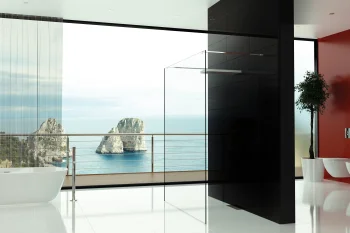 Minimalist bathroom with white floor, freestanding tub left, glass shower panel, black pillar, red wall, and a sea view with rocky formations outside.