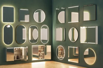 A green wall displaying a variety of backlit mirrors in different shapes—rectangles, circles and ovals—some with shelves or cabinets.