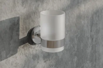 Wall-mounted frosted glass cylinder light with a chrome band on a textured grey wall, casting a shadow.