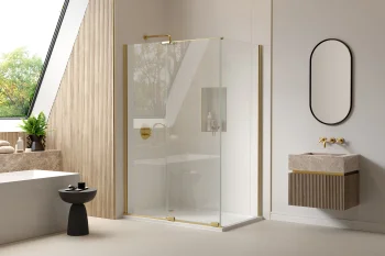 Modern bathroom with a glass shower enclosure and gold hardware, slatted wood wall, marble vanity, oval black mirror, and a potted plant by window.