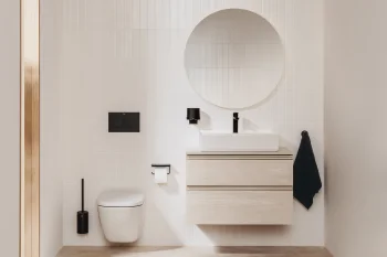 Minimalist bathroom with white tiled walls, a floating light-wood vanity and white sink, black faucet, round mirror, a wall-hung toilet, and a towel.