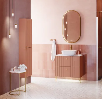 Pink-toned bathroom featuring a marble vanity, an oval backlit gold mirror, pendant lights, gold fittings, tiled walls, a shower and a freestanding tub.