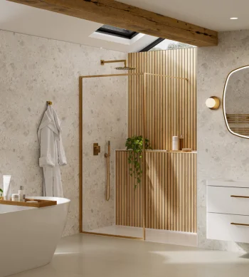 Bright contemporary bathroom with a freestanding white tub, glass shower with wooden slats, skylight, white vanity, oval backlit mirror and gold fixtures.