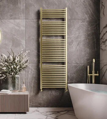 Luxurious bathroom with a gold towel radiator on dark marble walls, a white freestanding tub with a gold faucet, and a slatted cabinet with dried flowers.