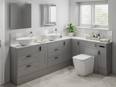 Modern grey bathroom with a double marble-topped vanity, two vessel sinks, patterned tile backsplash, mirrors, a plant by the window, and a toilet.