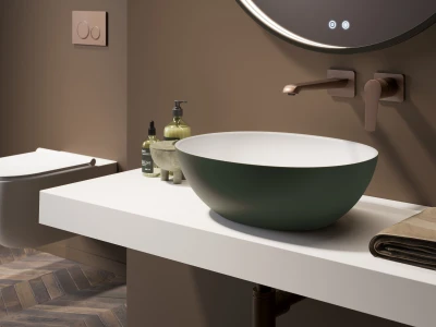 Bathroom with a round green-bowl sink on a white counter, wall-mounted tap, circular backlit mirror, soap bottles, folded towel, and a wooden floor.