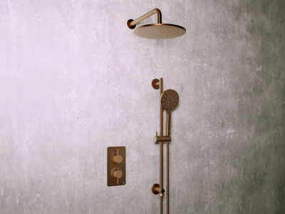 Bronze shower system with a large round rain head and a handheld head on a vertical bar, plus a dual-knob control plate on a textured grey wall.