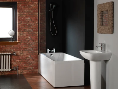 Contemporary bathroom with a white bathtub and pedestal sink against a black wall, brick feature wall, wooden floor, and a round mirror by a window.