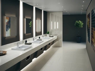 Modern restroom with a long white countertop and several square sinks, backlit mirrors, dark walls, ceiling spotlights, and a potted tree in the corner.