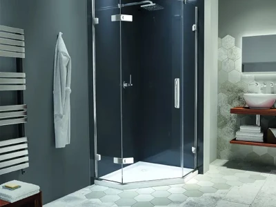 Modern bathroom with a glass corner shower enclosure, chrome fittings, dark blue walls, hex floor tiles, and a wooden vanity with a vessel sink.