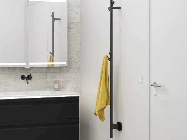 Modern bathroom with white sink on a black vanity, black wall faucet, LED mirrored cabinets, tile wall, and tall black towel rack with a yellow towel.