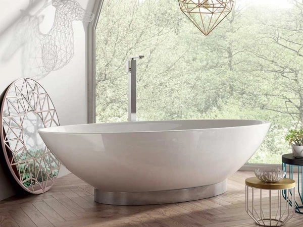 Bright modern bathroom with a white tub by a large window overlooking greenery; geometric decor, lattice mirror, deer silhouette shadow, and pendant light.