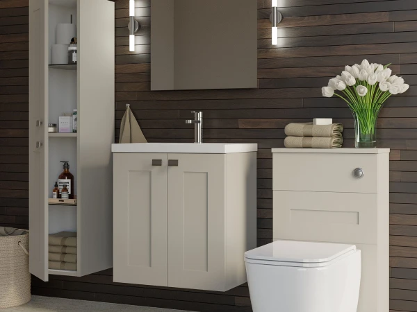 Modern bathroom featuring a beige vanity and sink, a toilet, dark wood panel walls, a tall storage cabinet, and a vase of white tulips with towels.