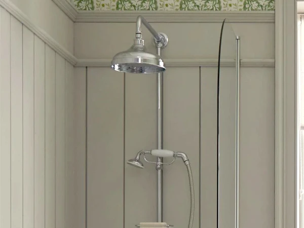Shower over a white tub with chrome fixtures, including a rain head and handheld spray; glass screen, pale panelled walls and a green floral border.