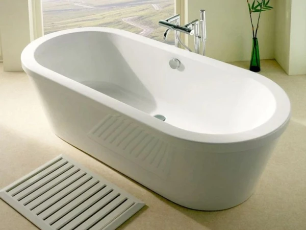 Modern white freestanding bathtub in a bright bathroom, chrome tap, a slatted floor vent in the foreground, and a green plant in a vase nearby.