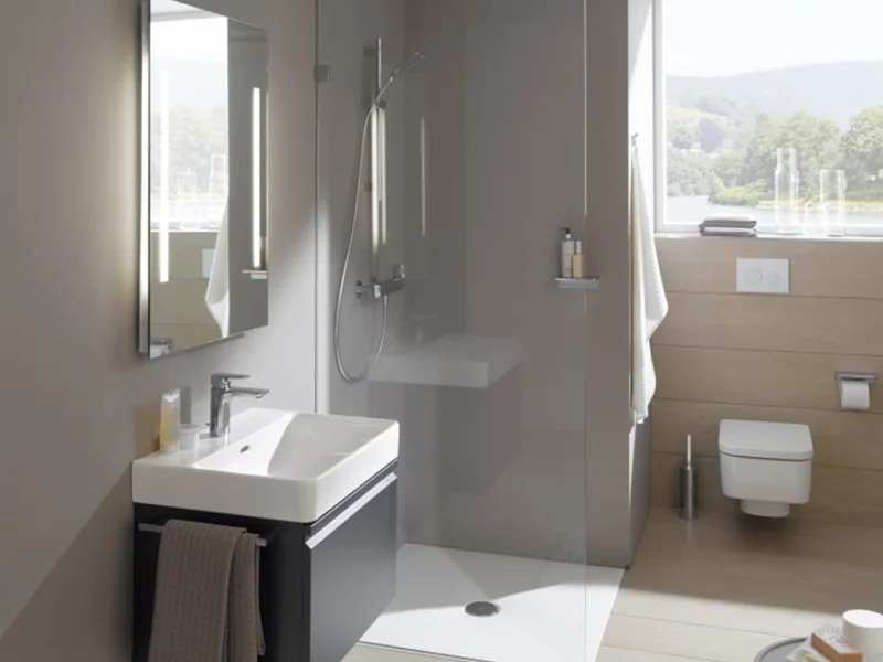 Modern bathroom with a glass-walled shower, wall-mounted white sink on a dark vanity, and a window offering a countryside view.